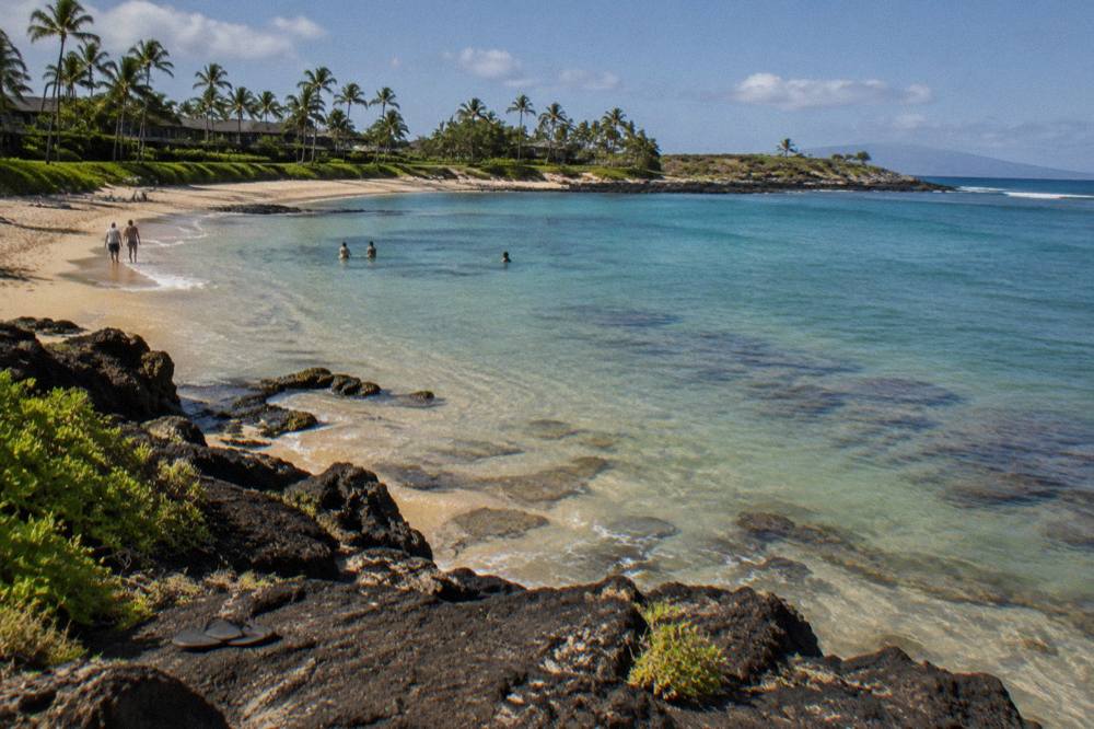 A calm south shore bay with turquoise water and a rocky point in the distance